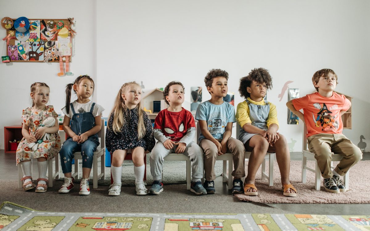 Bambini seduti che guardano un punto con attenzione